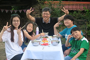 많은 사람들이 정원에서 공연을 보고 있는 사진이미지