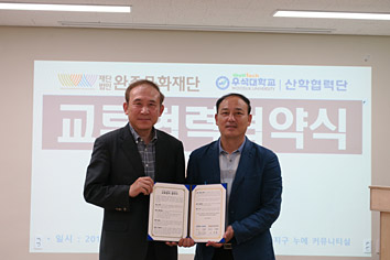 서류를 들고  교류협력체결하는 사진