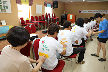 일렬로 서로 등을 주며 등쪾에 그림그려주는 사진